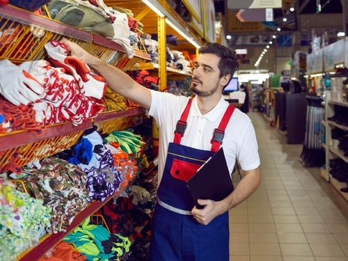 Salesperson checking safety gloves, construction gloves, safety helmets, safety masks, safety jackets, and more at Starlinks